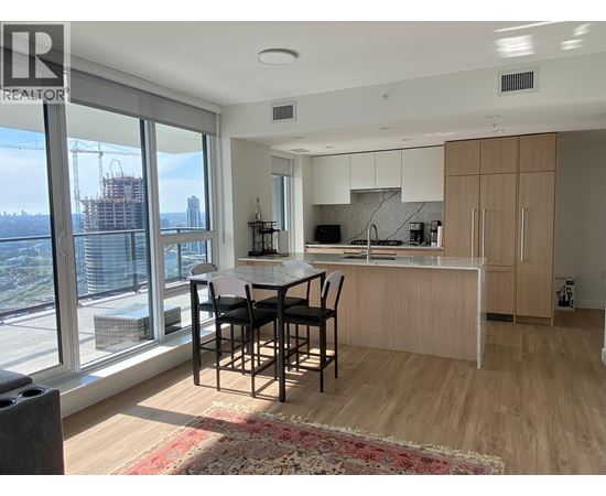 A modern kitchen with a dining table and chairs.