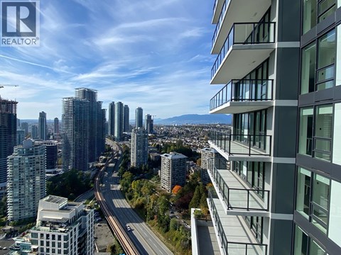 A cityscape with a highway and buildings in the background.