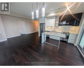A well-lit kitchen with dark wood floors and modern appliances.