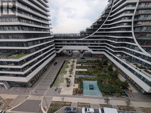 A view of a courtyard with a pool and a fountain in the middle surrounded by buildings.