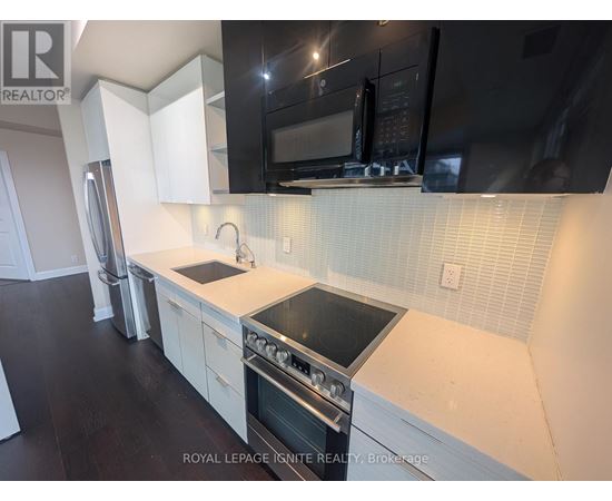 A kitchen with white cabinets and black appliances.