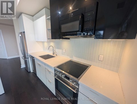 A kitchen with white cabinets and black appliances.