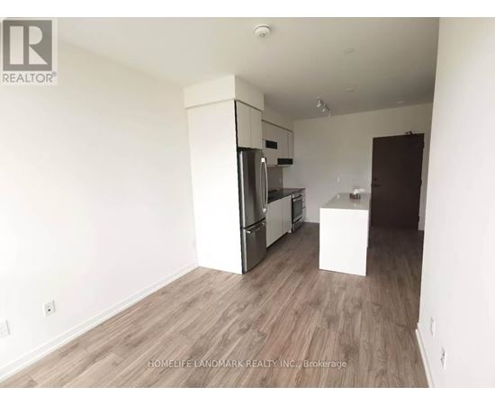 A kitchen area with a refrigerator, oven, and microwave.