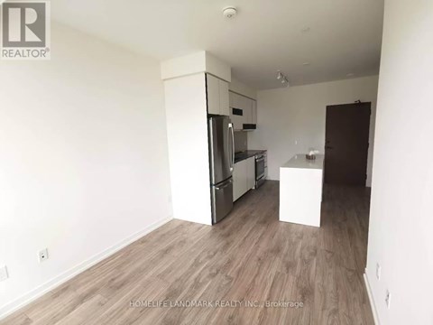 A kitchen area with a refrigerator, oven, and microwave.