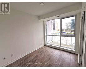 A room with a large window and wooden flooring.