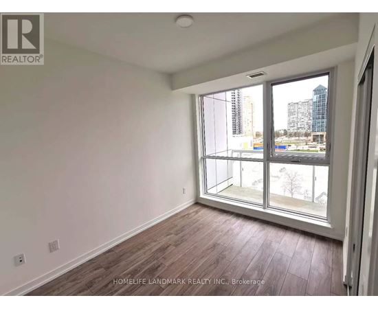 A room with a large window and wooden flooring.