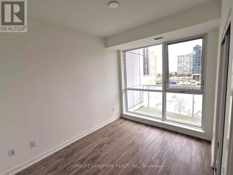 A room with a large window and wooden flooring.