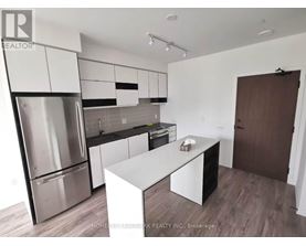 A modern kitchen with stainless steel appliances and white cabinetry.