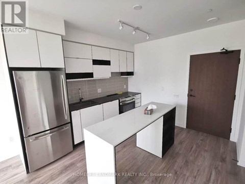 A modern kitchen with stainless steel appliances and white cabinetry.