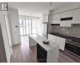 A kitchen with white cabinets and a black dishwasher.