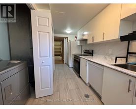 A kitchen with white cabinets and a white door.