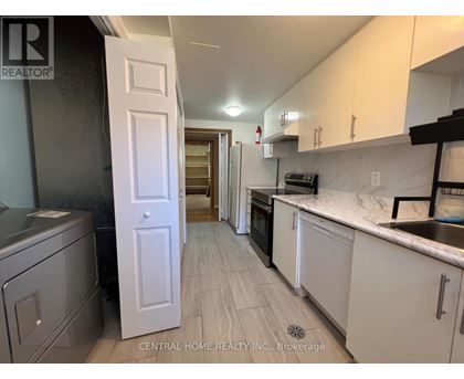 A kitchen with white cabinets and a white door.
