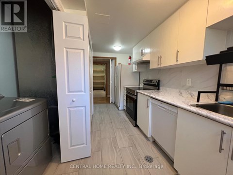A kitchen with white cabinets and a white door.