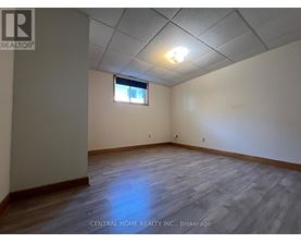 A room with wooden flooring and a window with a white frame.