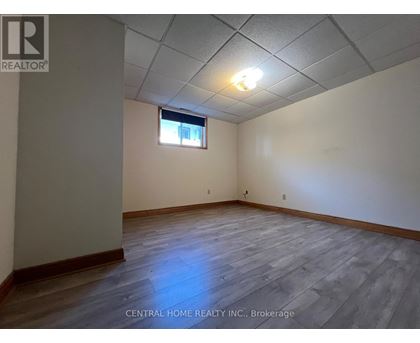 A room with wooden flooring and a window with a white frame.