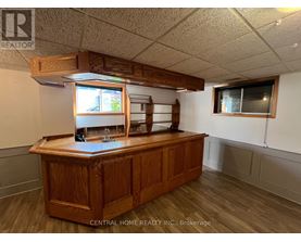 A wooden reception desk with a window above it in a room with white walls.