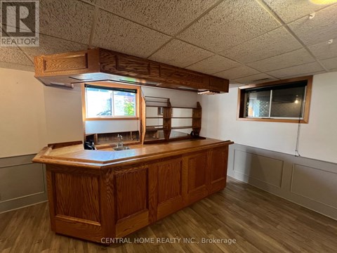 A wooden reception desk with a window above it in a room with white walls.