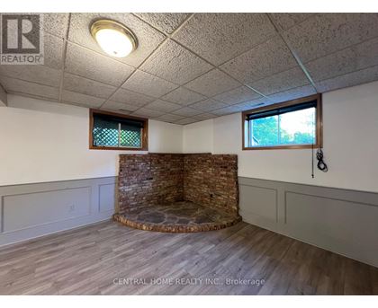 A room with a stone fireplace and wood flooring.