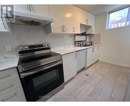 A kitchen with a black stove top oven and white cabinets.