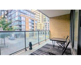 A balcony with a table and chairs overlooking a city street.