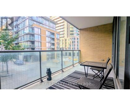 A balcony with a table and chairs overlooking a city street.