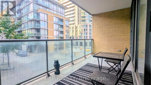 A balcony with a table and chairs overlooking a city street.