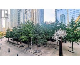 A city park with trees and a sculpture in the middle.