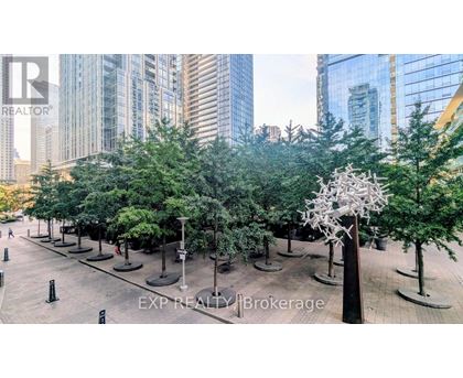 A city park with trees and a sculpture in the middle.