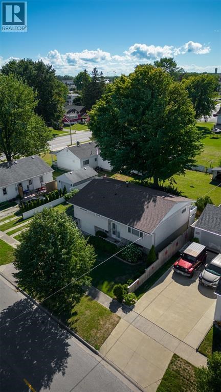 A house with a white garage door is surrounded by trees.