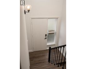 A white door with a window above it and a light on the wall.