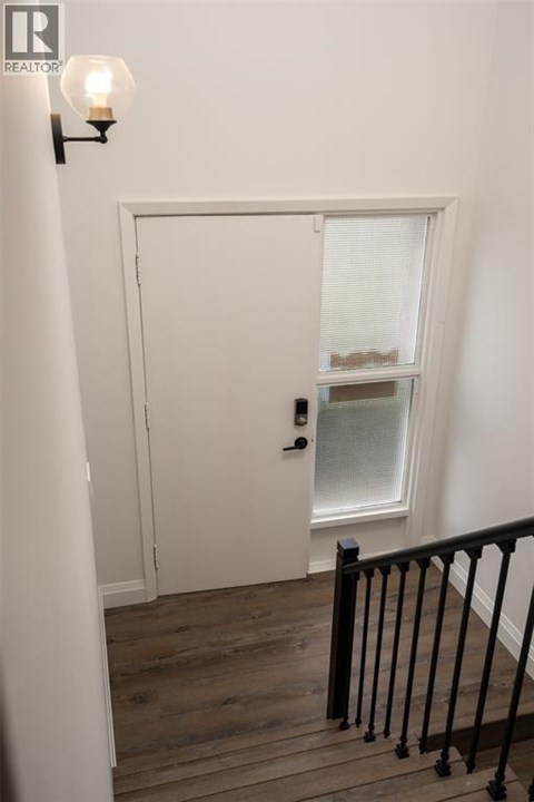 A white door with a window above it and a light on the wall.