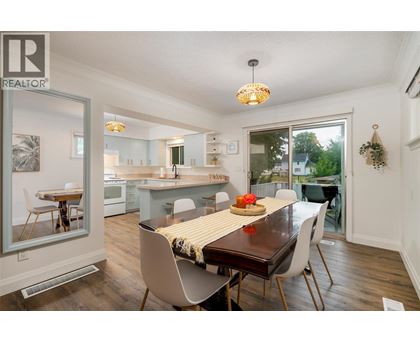 A dining room with a table set for two and a view of the backyard.