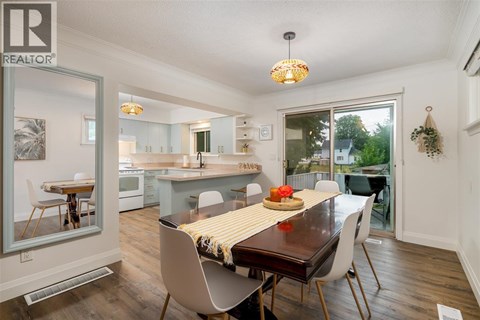 A dining room with a table set for two and a view of the backyard.