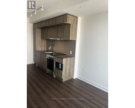 A modern kitchen with wooden cabinets and a stainless steel sink.