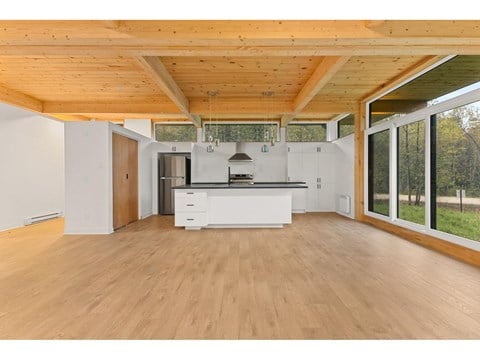 A spacious kitchen with wooden floors and a white countertop.