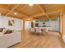 A spacious living room with a couch, chairs, and a dining table.