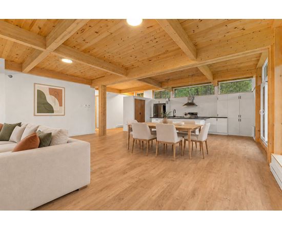 A spacious living room with a couch, chairs, and a dining table.