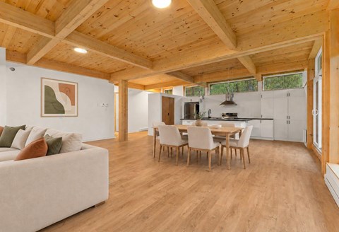 A spacious living room with a couch, chairs, and a dining table.