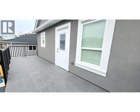 A grey house with a white door and window.