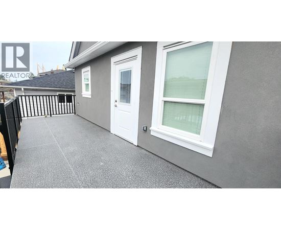 A grey house with a white door and window.