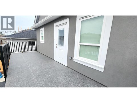 A grey house with a white door and window.