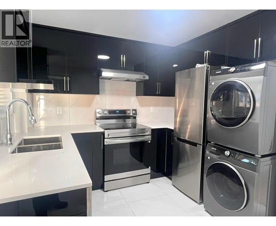 A modern kitchen with a stainless steel refrigerator, oven, and dishwasher.