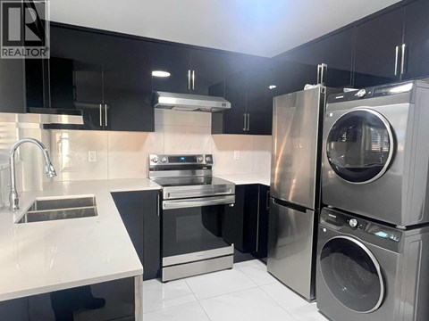 A modern kitchen with a stainless steel refrigerator, oven, and dishwasher.