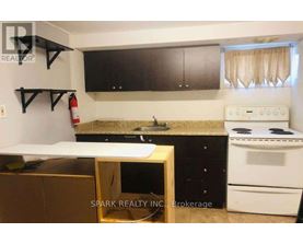 A kitchen with a white stove and black cabinets.