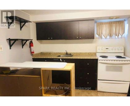 A kitchen with a white stove and black cabinets.