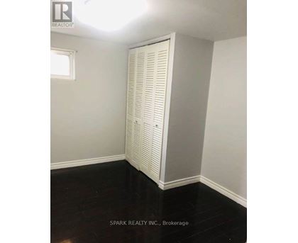 A room with a white closet and black flooring.
