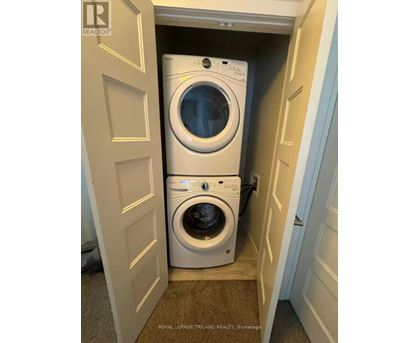 A white washing machine is in a small space between two doors.
