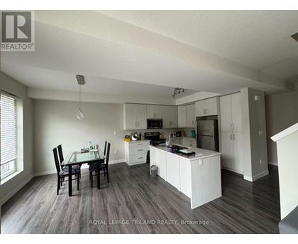 A well-lit kitchen with a dining table and chairs.