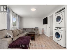 A living room with a couch, a coffee table, and a washing machine in the corner.