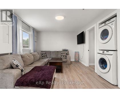 A living room with a couch, a coffee table, and a washing machine in the corner.